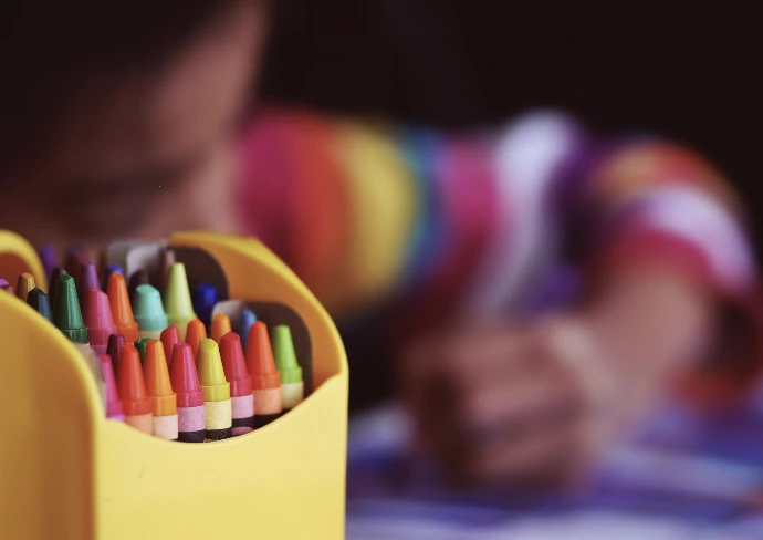 selective focal photo of crayons in yellow box